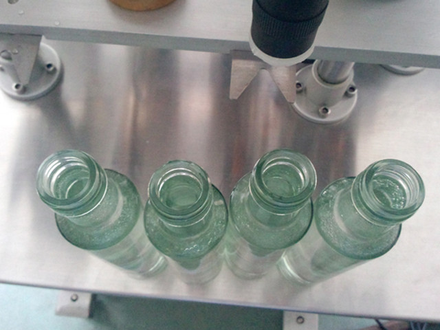bottles to be filled by YX-V04 vacuum liquid filling machine